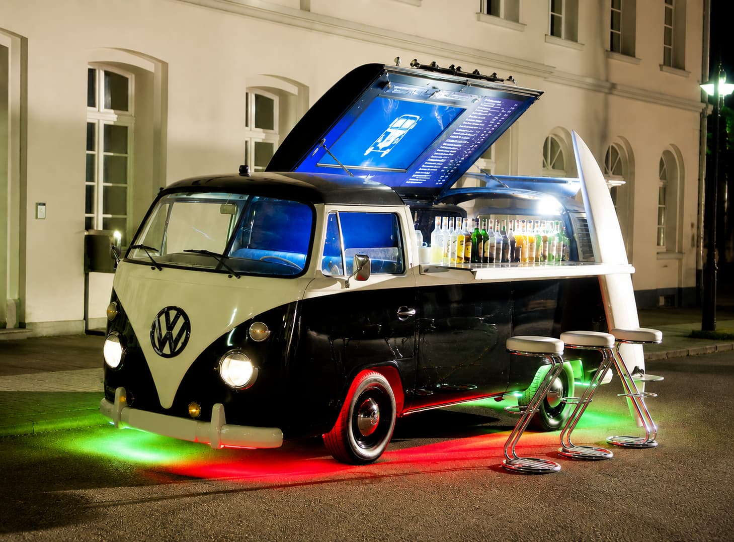 Black and white VW T1 split-screen bar truck with dramatic LED underglow at night