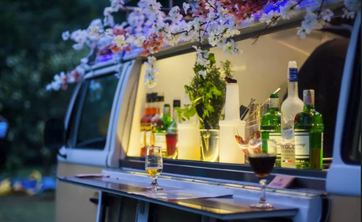 Black VW T2 bar truck with golden stripe and fairy lights at night