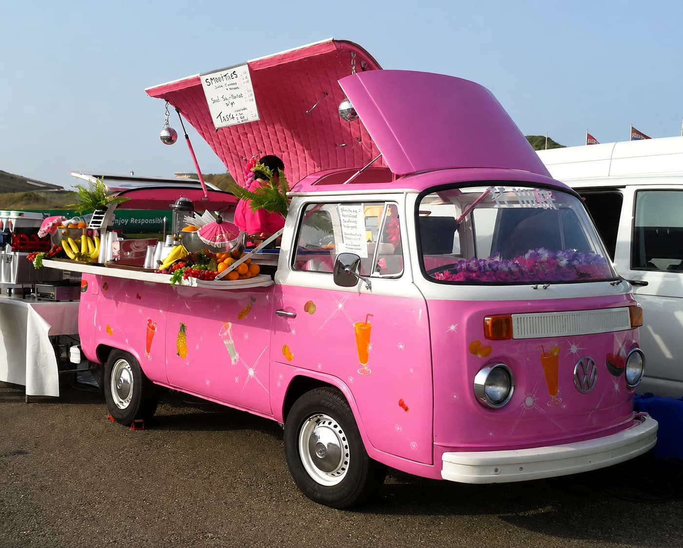 Hot pink VW T2 smoothie truck with fruity livery and fresh fruit on counter